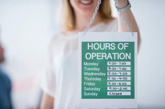 A woman holding up a sign saying the companies "operating hours."