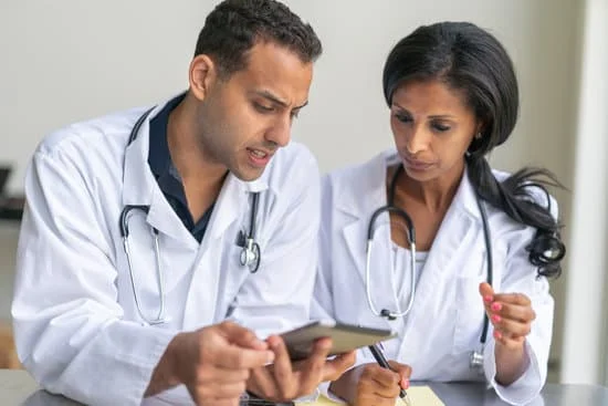 A male and a female doctor looking at an electronic tablet