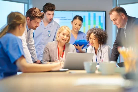 Dentists discussing Digital Marketing for the Dental Clinic and looking at a computer screen